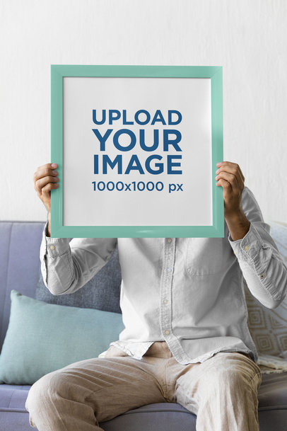 Placeit Mockup of a Man Holding a Squared Art Print While Sitting on